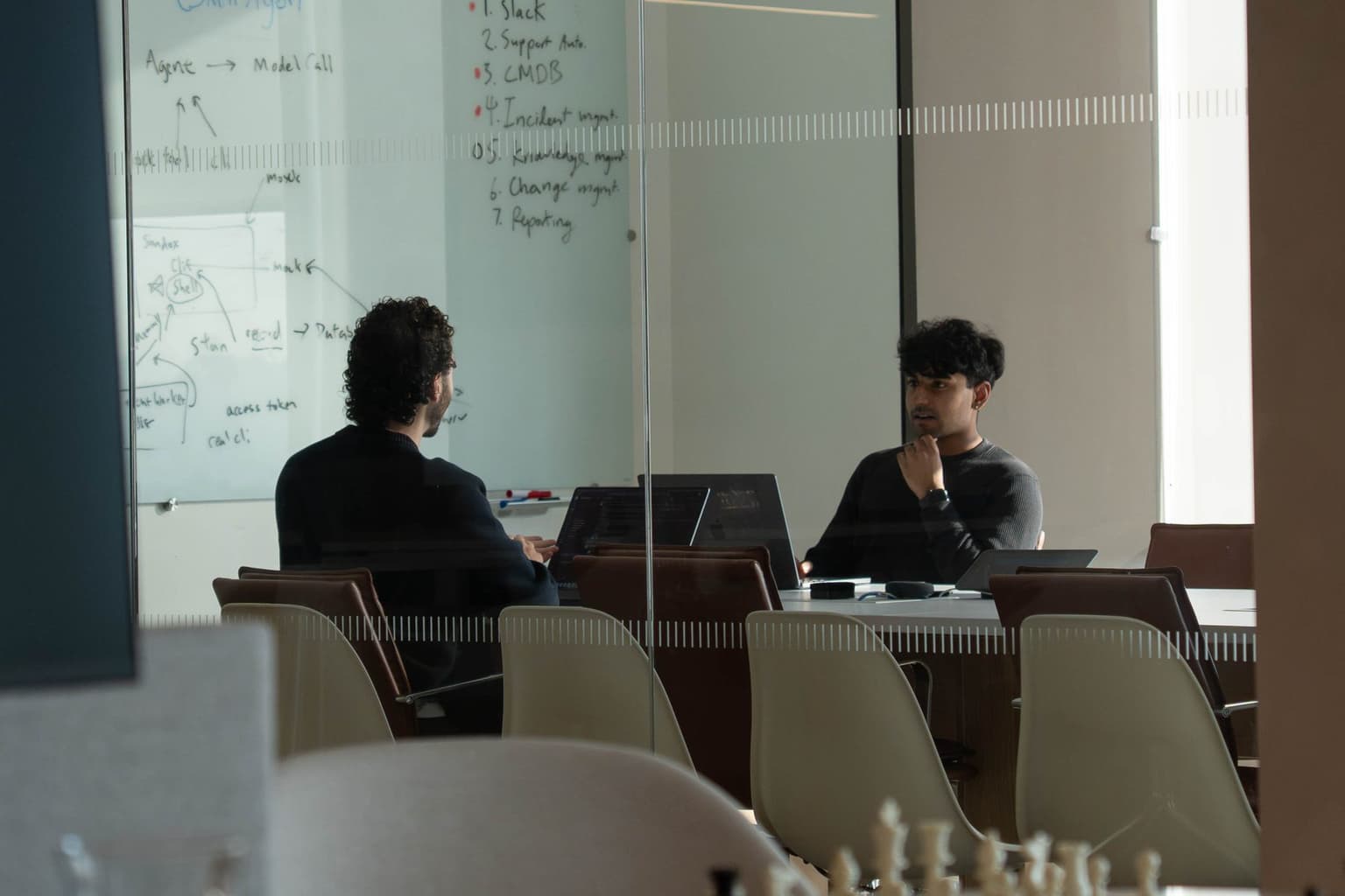 Two STLabs engineers talking through a design at the whiteboard